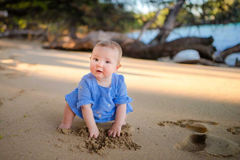 A baby touch beach sand in Hawaii.