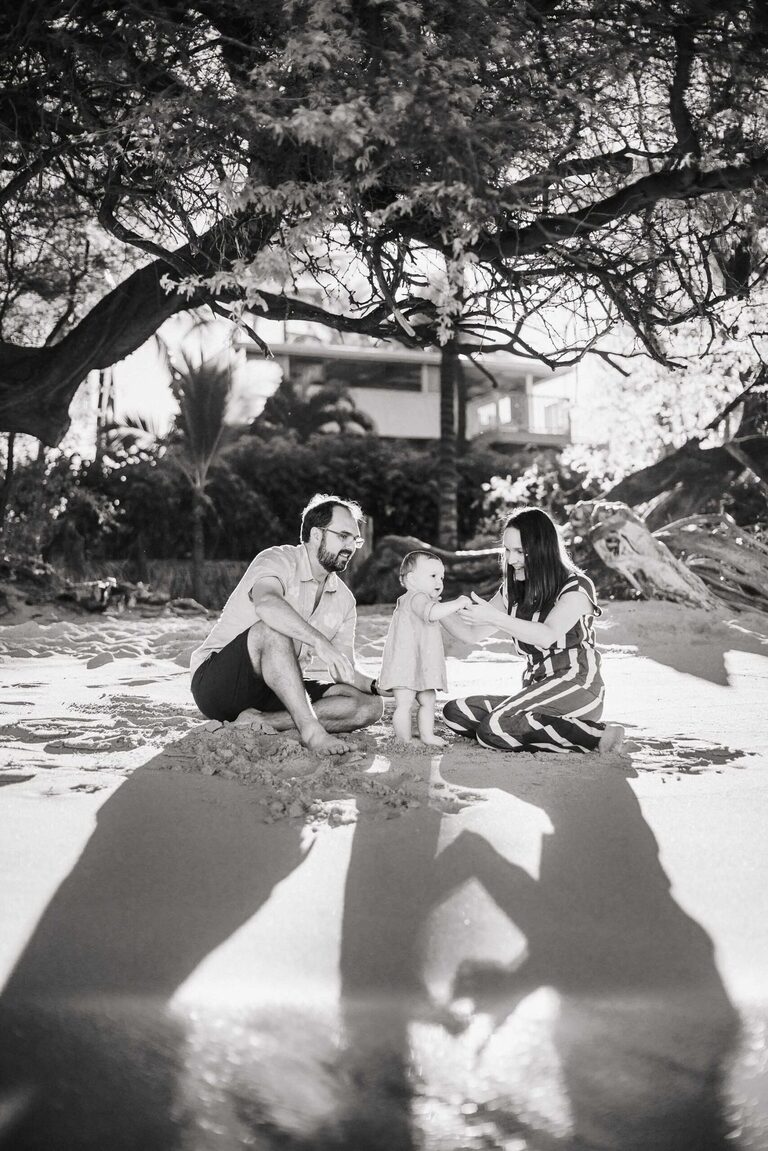 A family playing in the sand on the Big Island of Hawaii.
